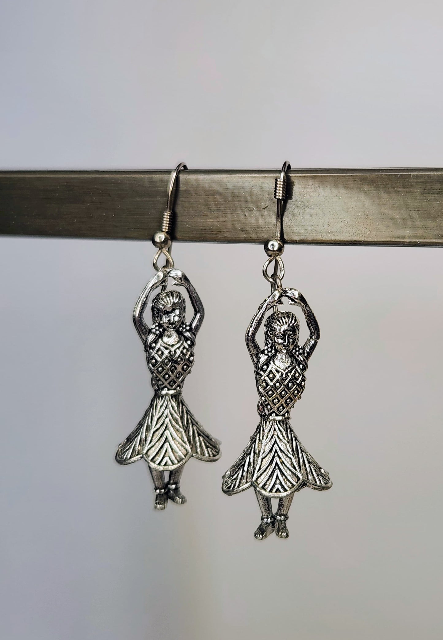 Silver dancer earrings on a white background