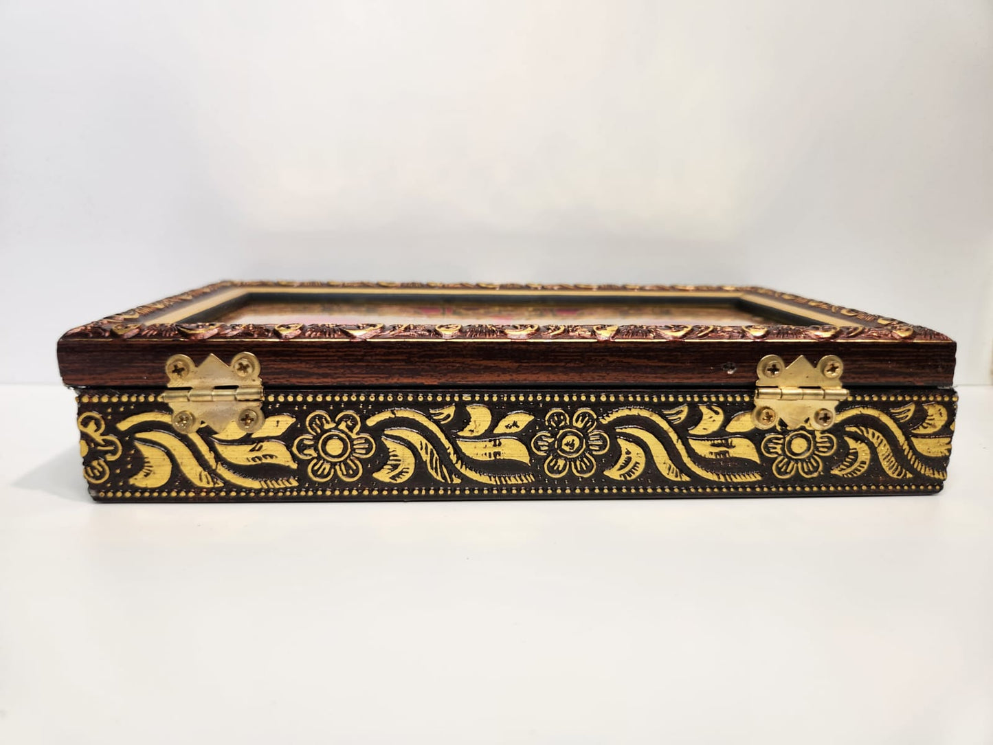Decorative wooden box with gold embellishments on a white background