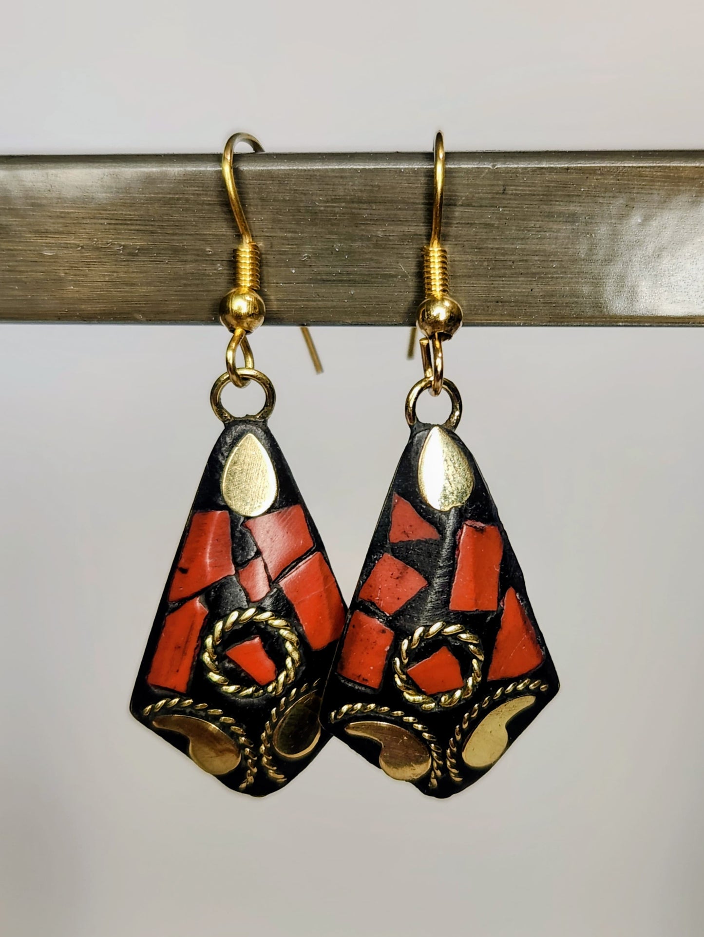 Pair of earrings with geometric design on a metallic surface