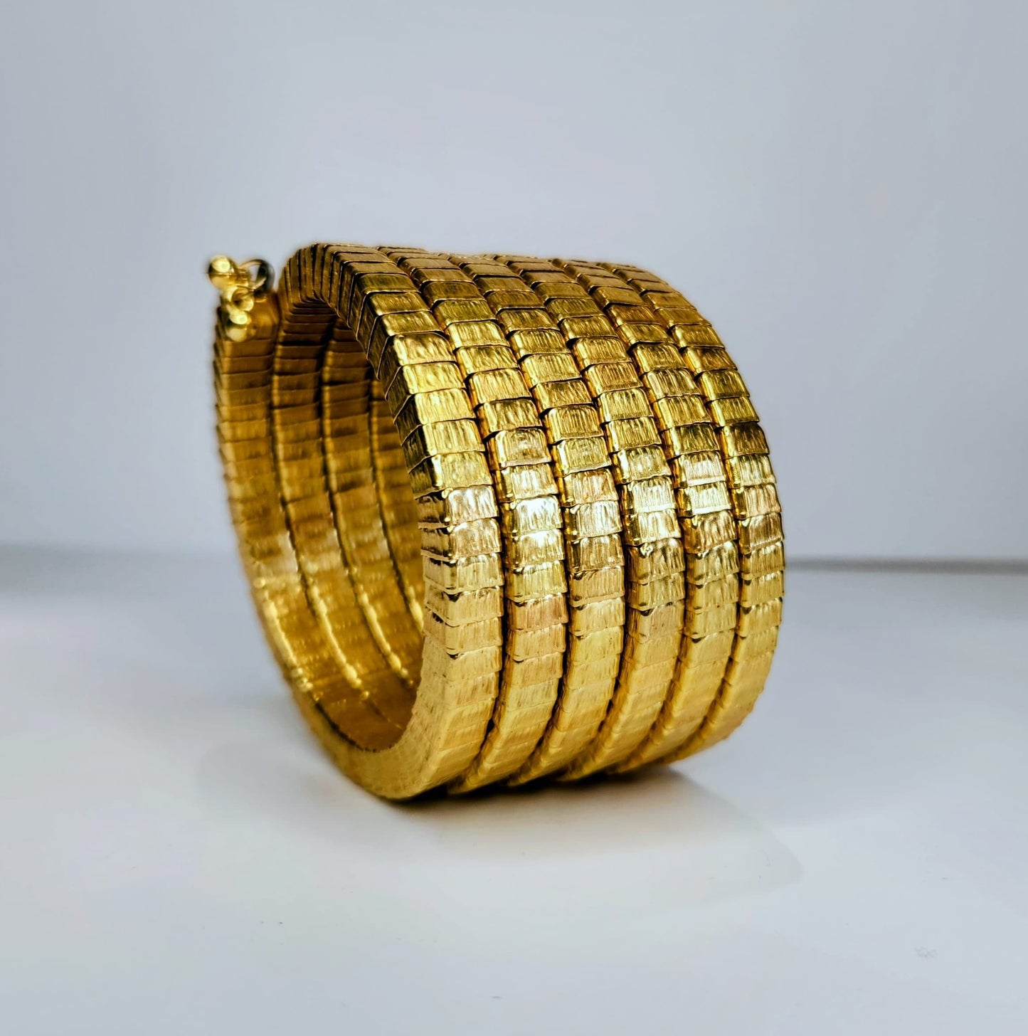 Gold bangle on a light gray background