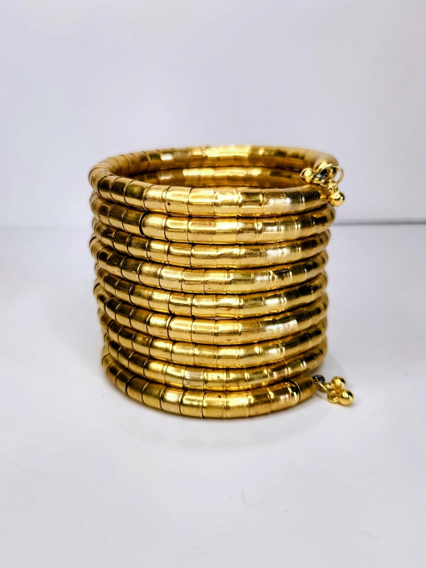 Stack of gold bangles on a white background