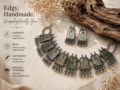 A handmade silver-toned Indian-style necklace and matching earrings displayed on a textured beige fabric with dried floral accents and a piece of driftwood. The left side features marketing text highlighting the product's handcrafted quality, premium metal, lightweight design, and authentic Indian origin.