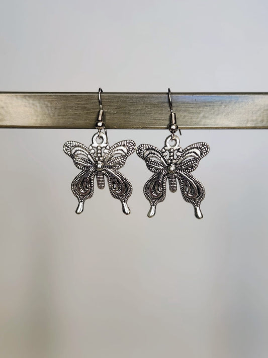 Butterfly-shaped earrings on a gray background