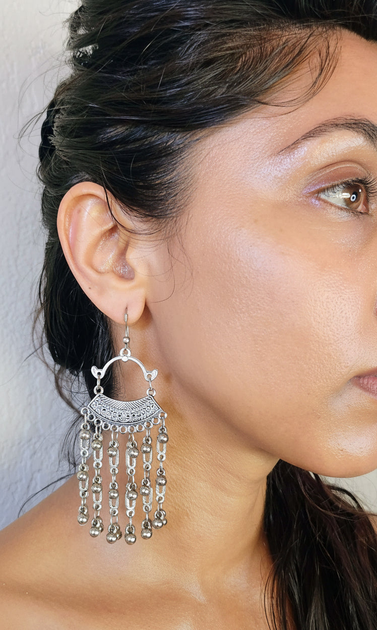 modeling the chandelier earrings that are metal and handmade