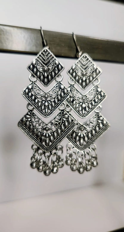 Pair of silver earrings with geometric design on a white background