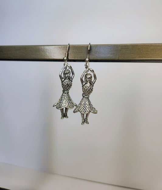 Silver dancing girl earrings on a white background