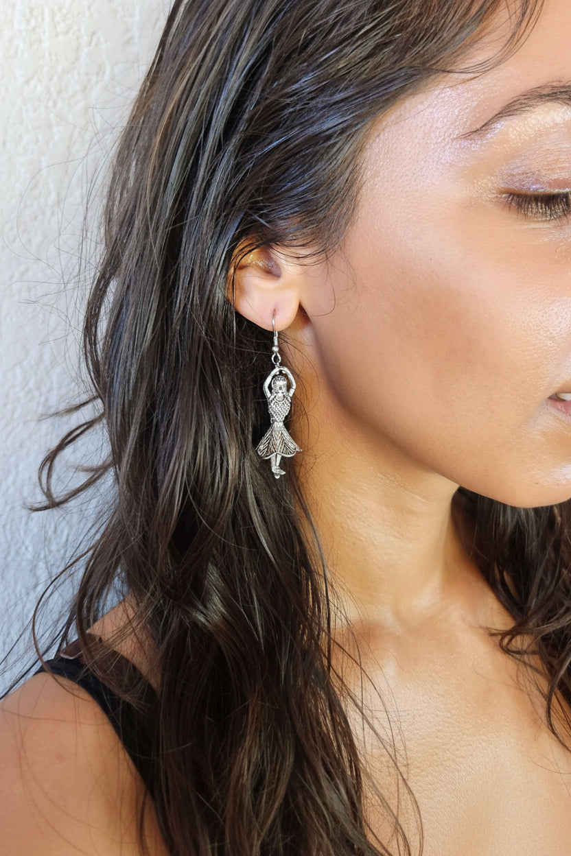 model wearing metal earrings of dancer with hands in the air