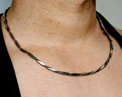 Necklace on a person's neck with a neutral background