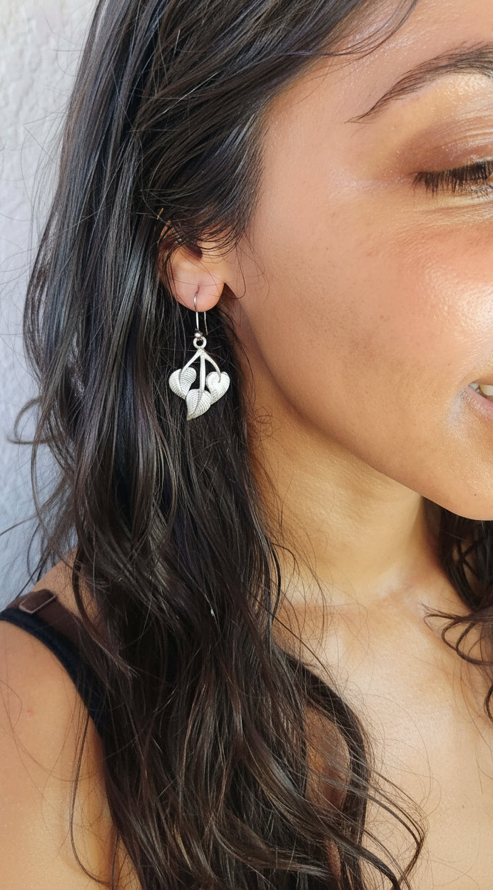 model wearing peepal leaf earrings in metal and handmade