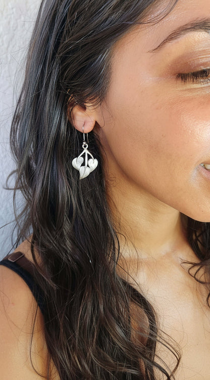 model wearing peepal leaf earrings in metal and handmade