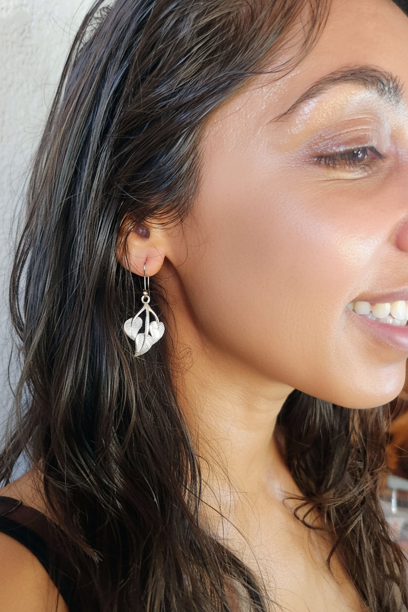 model wearing peepal leaf earrings in metal, handmade