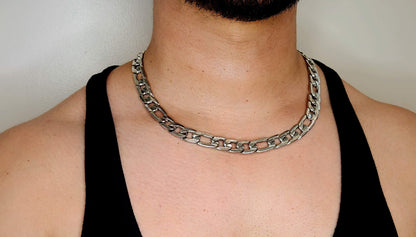 Person wearing a silver chain necklace against a neutral background